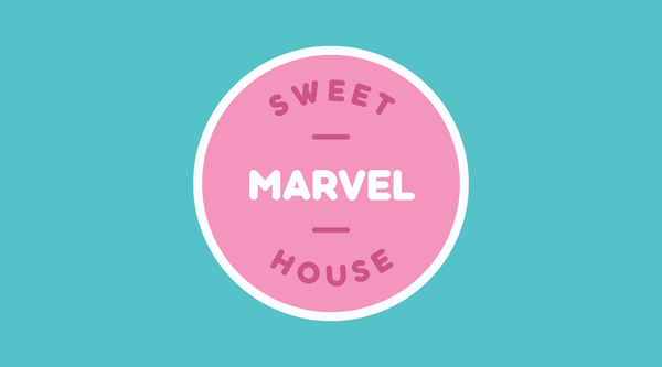 Das Favicon-Bild zeigt ein rundes Logo mit einem rosa Kreis auf einem türkisfarbenen Hintergrund. In der Mitte des Kreises steht in weißen Großbuchstaben das Wort "MARVEL". Darüber und darunter befinden sich die Wörter "SWEET" und "HOUSE" in einem dunkleren Rosa. Das Logo wirkt freundlich und einladend, passend zu einem süßen Geschäft 